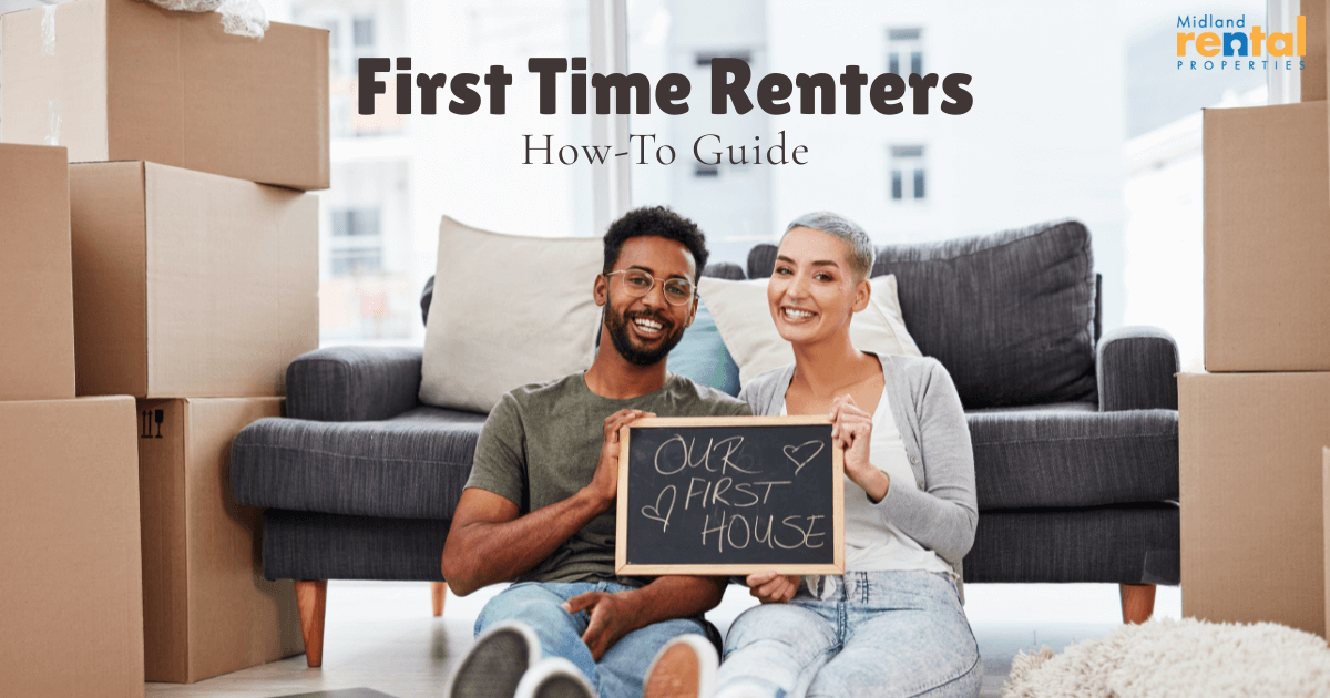 Smiling couple surrounded by moving boxes holding a sign that reads “Our First House,” illustrating a how-to guide for first-time renters.