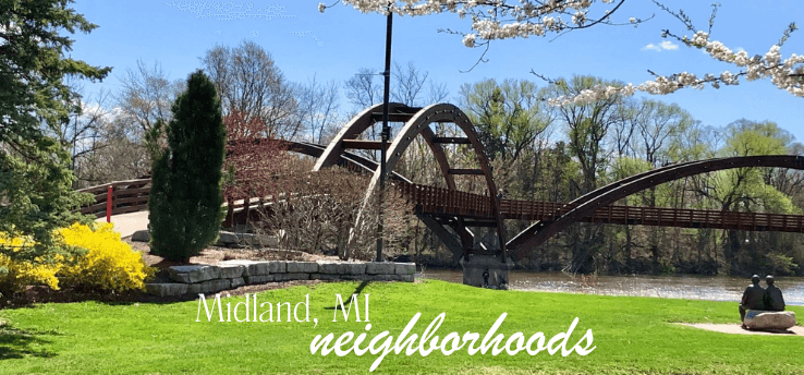 The Tridge footbridge in Midland, MI on a sunny spring day with green lawn and blooming trees—hero image for the neighborhoods guide.