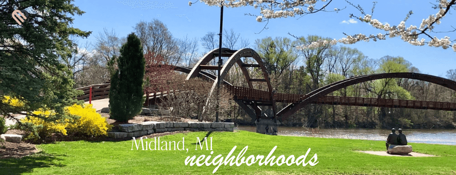 The Tridge footbridge in Midland, MI on a sunny spring day with green lawn and blooming trees—hero image for the neighborhoods guide.