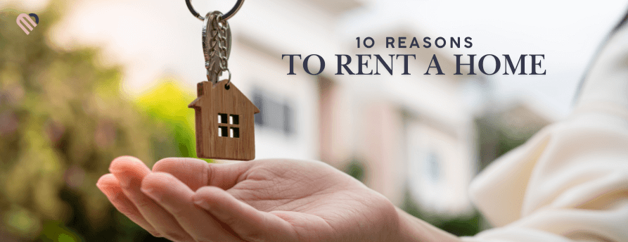 Hand holding a small wooden house keychain over an open palm, representing renting a home — feature image for ‘10 Reasons to Rent a Home’ in Midland, MI.